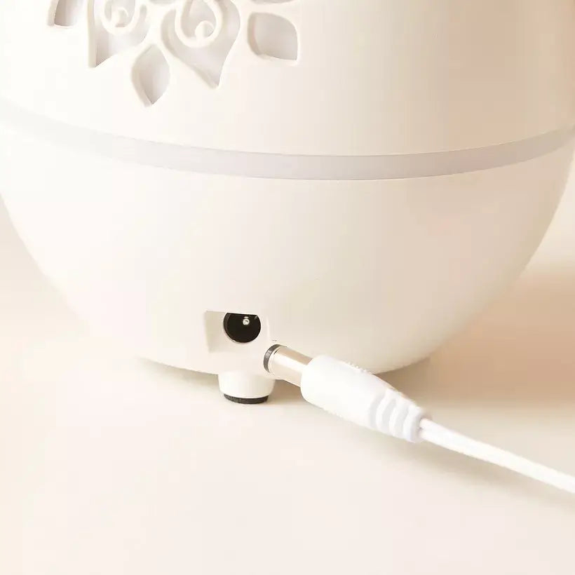 White diffuser with a white cable on a light beige background