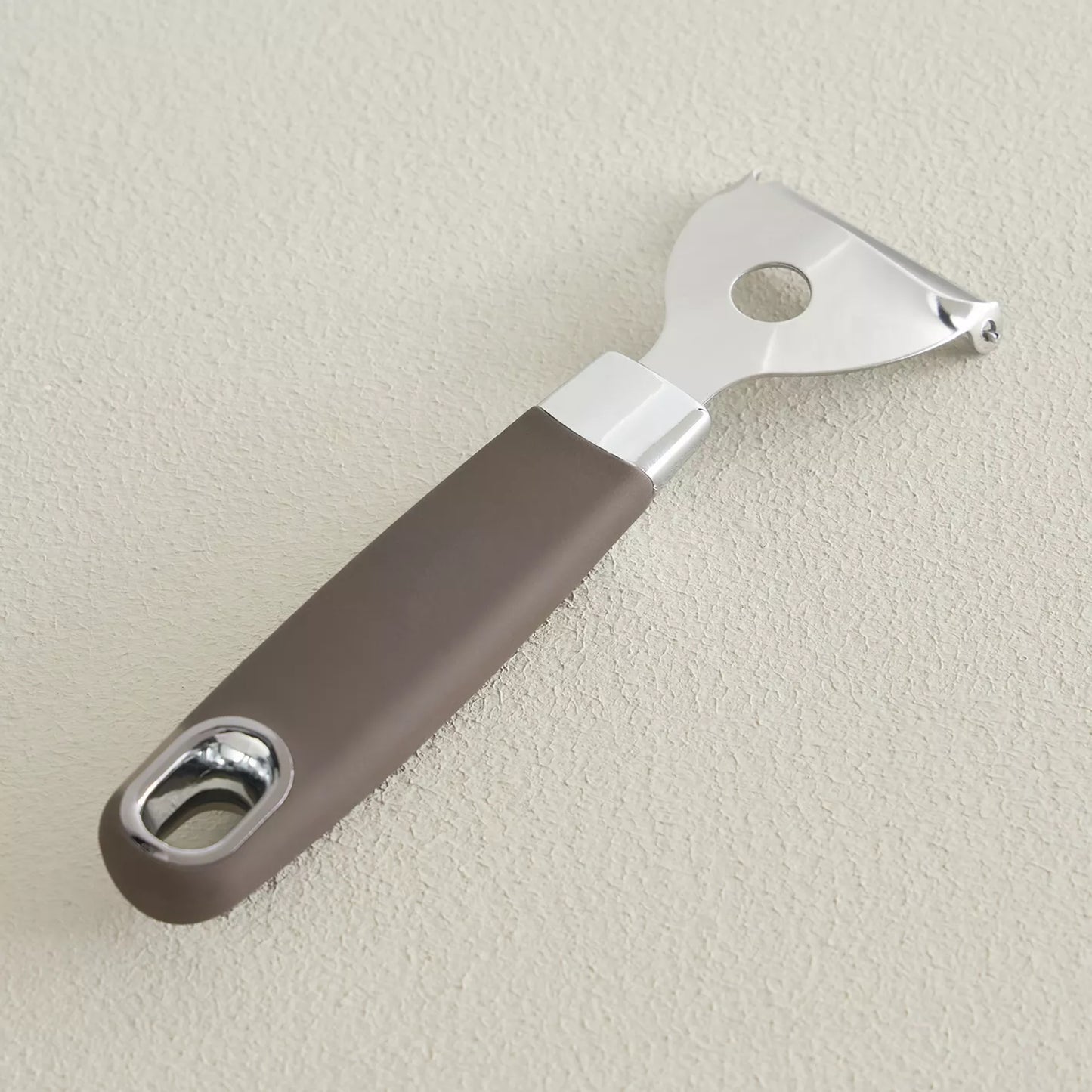 Bottle opener with brown handle and silver accents on a beige background