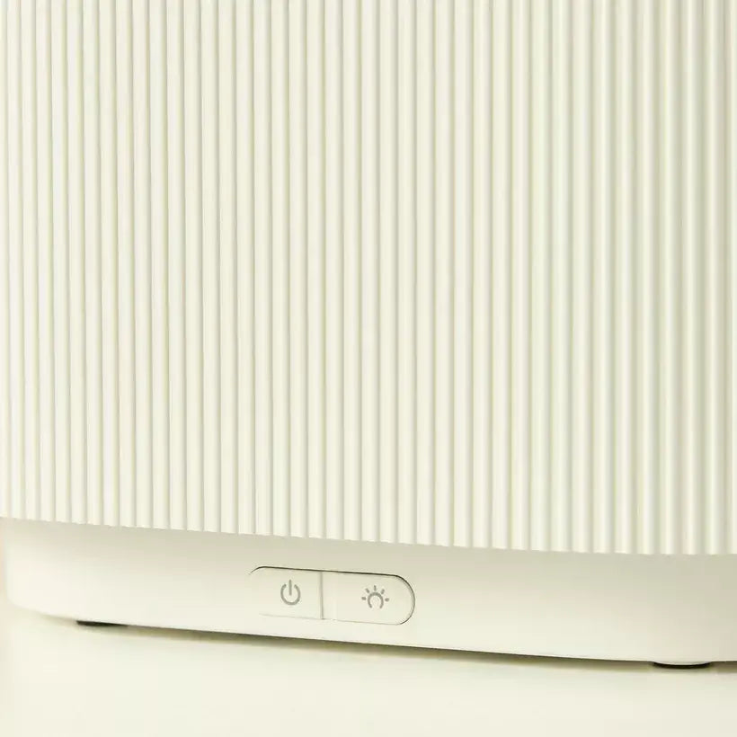 Close-up of a white electronic device with control buttons on a light background