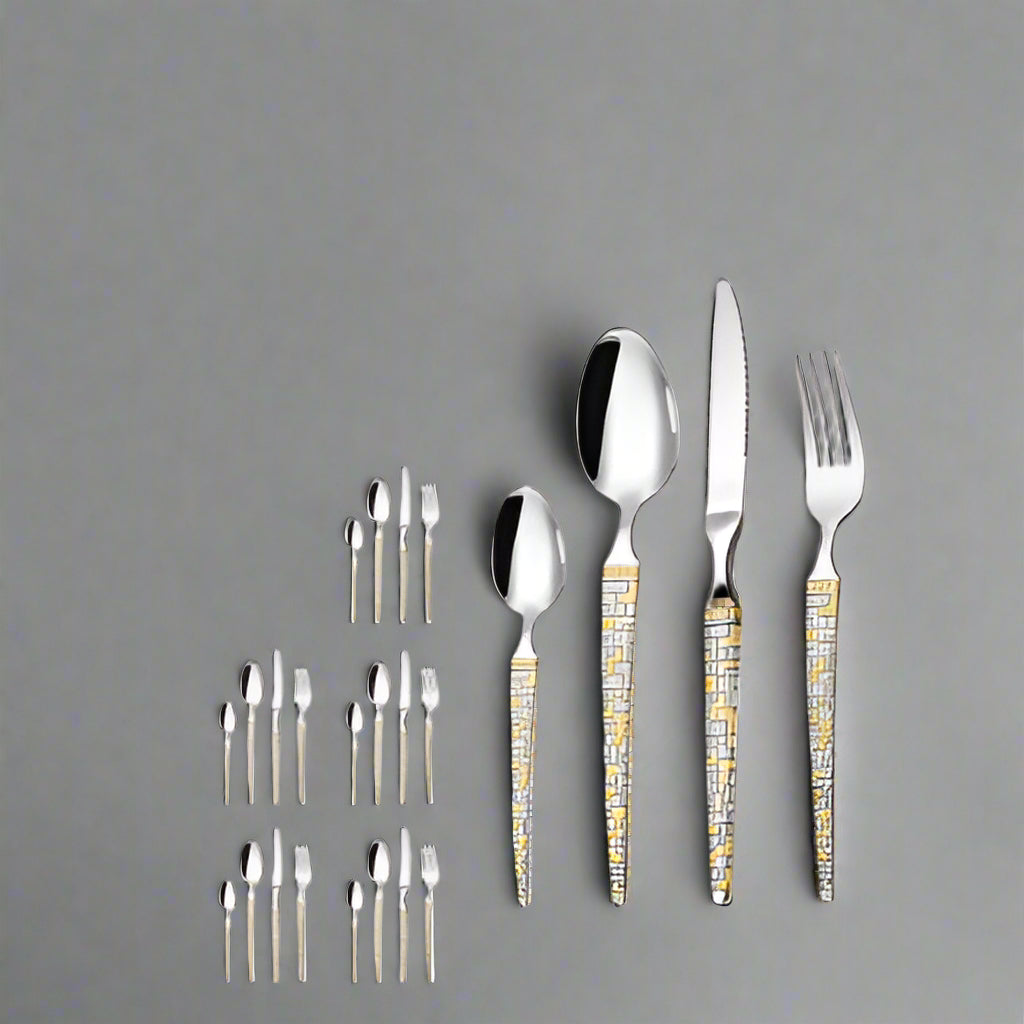 Silver cutlery set with gold accents on a white background