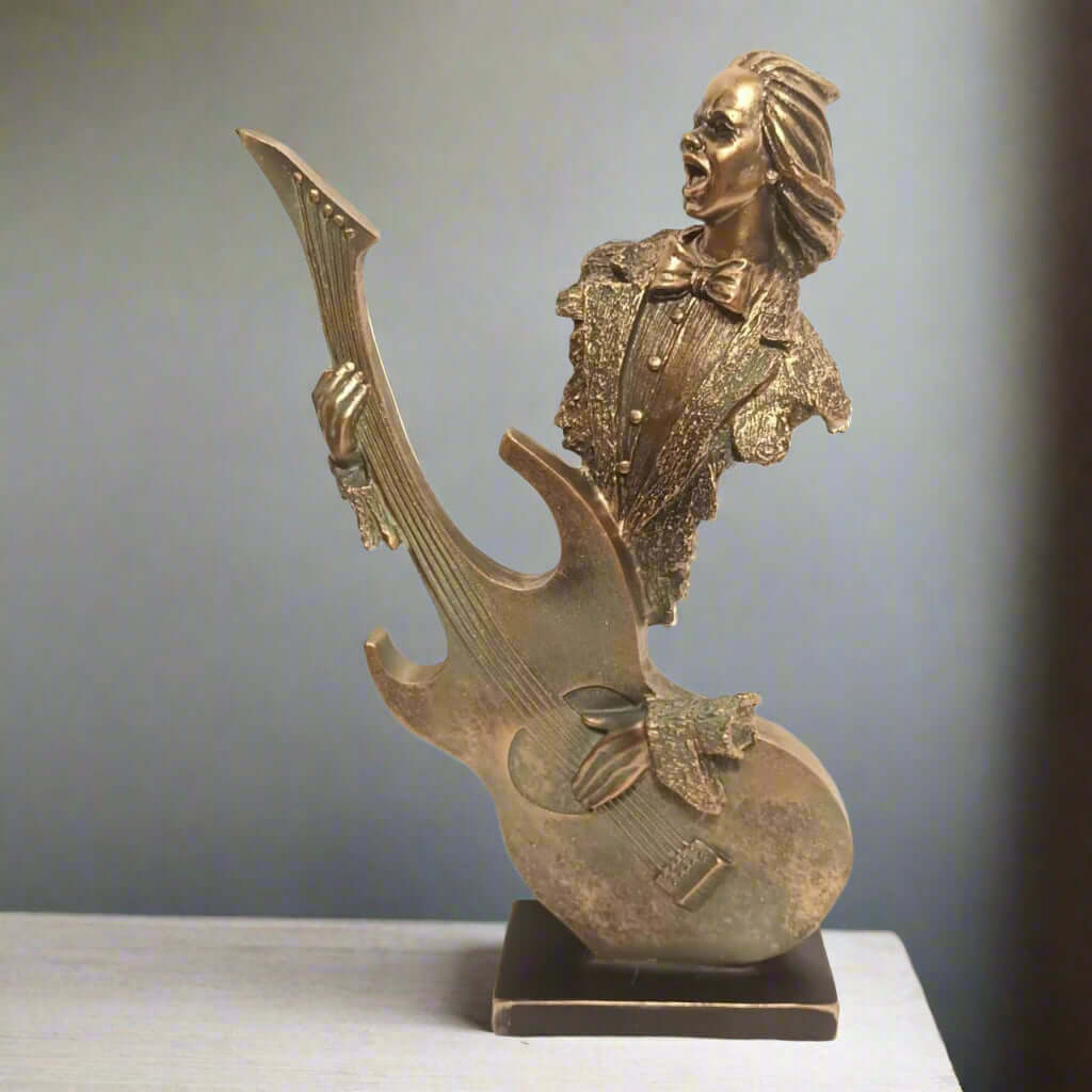 Gold statue of a guitar player with a guitar on a gray background