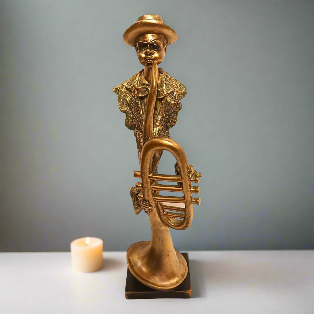 Gold statue of a person playing a horn on a gray background