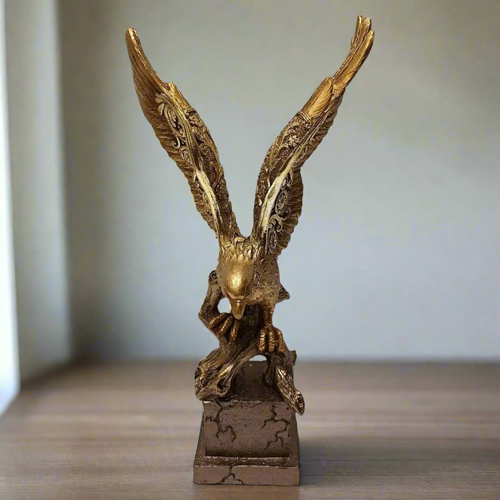 Gold eagle statue on a wooden surface with a neutral background