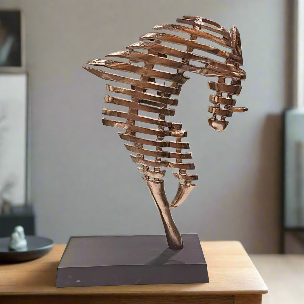 Bronze seahorse sculpture on a wooden stand against a neutral background