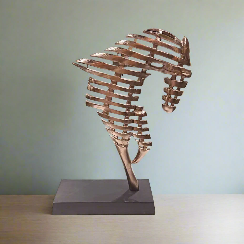 Copper sculpture on a stand against a light green background