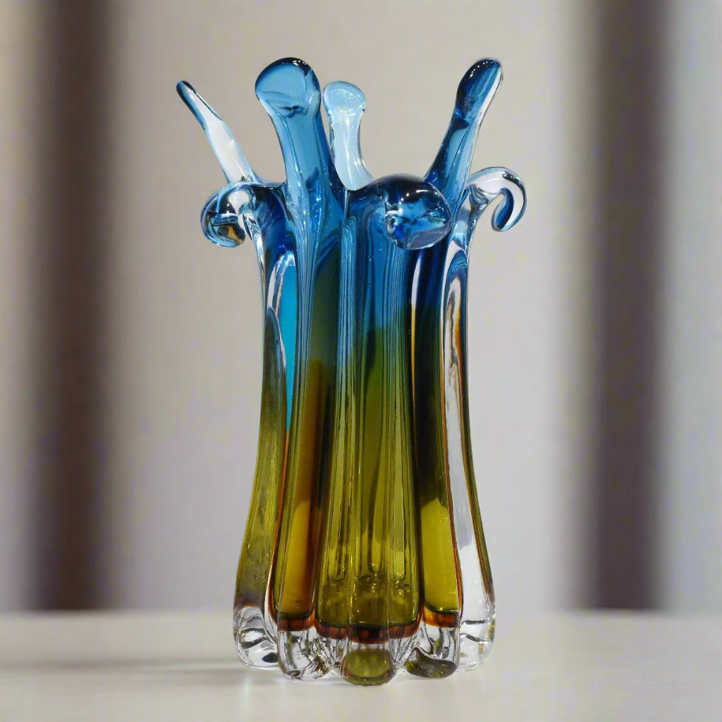 Colorful glass sculpture on a white surface with a light gray background