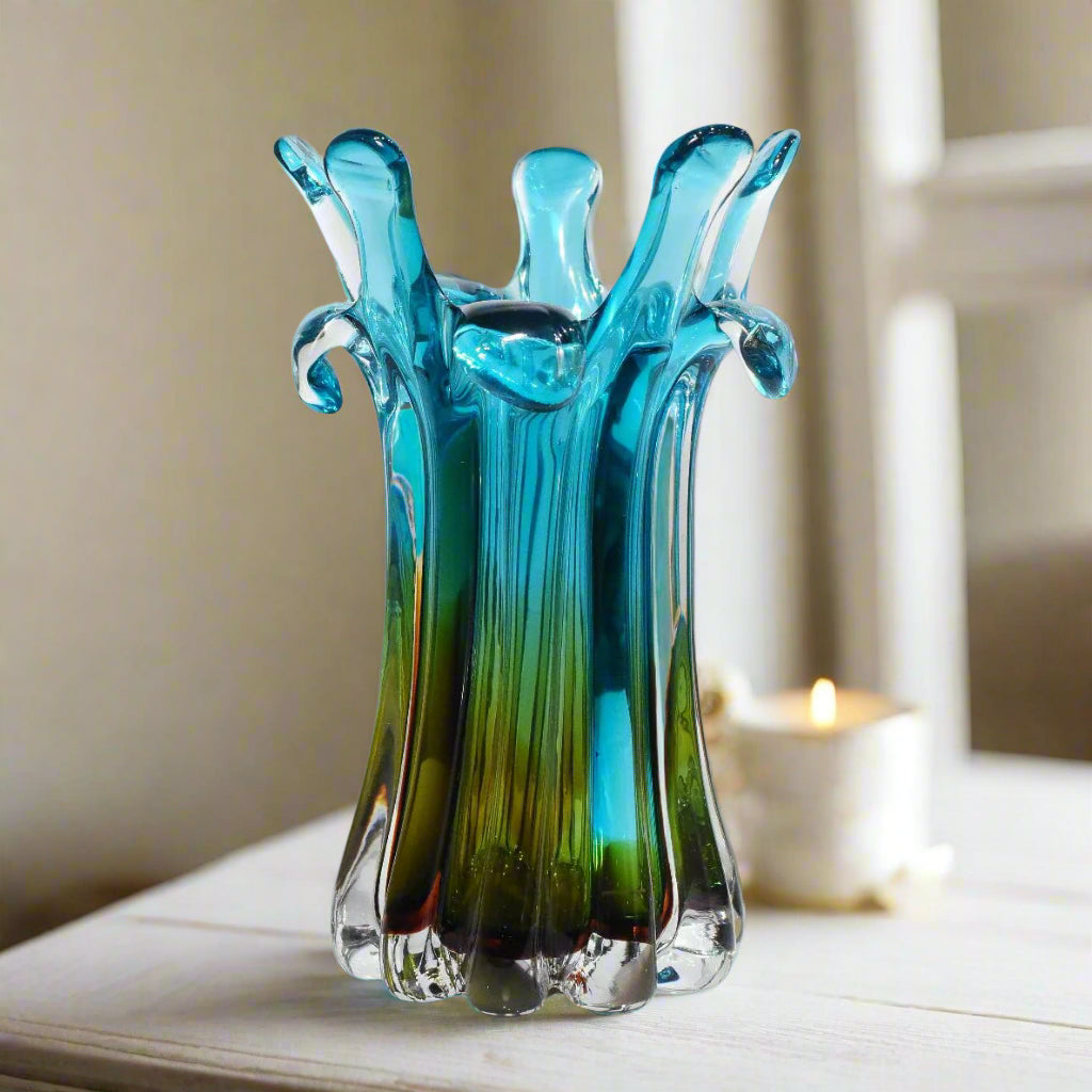 Blue and green glass vase with a unique design on a white background