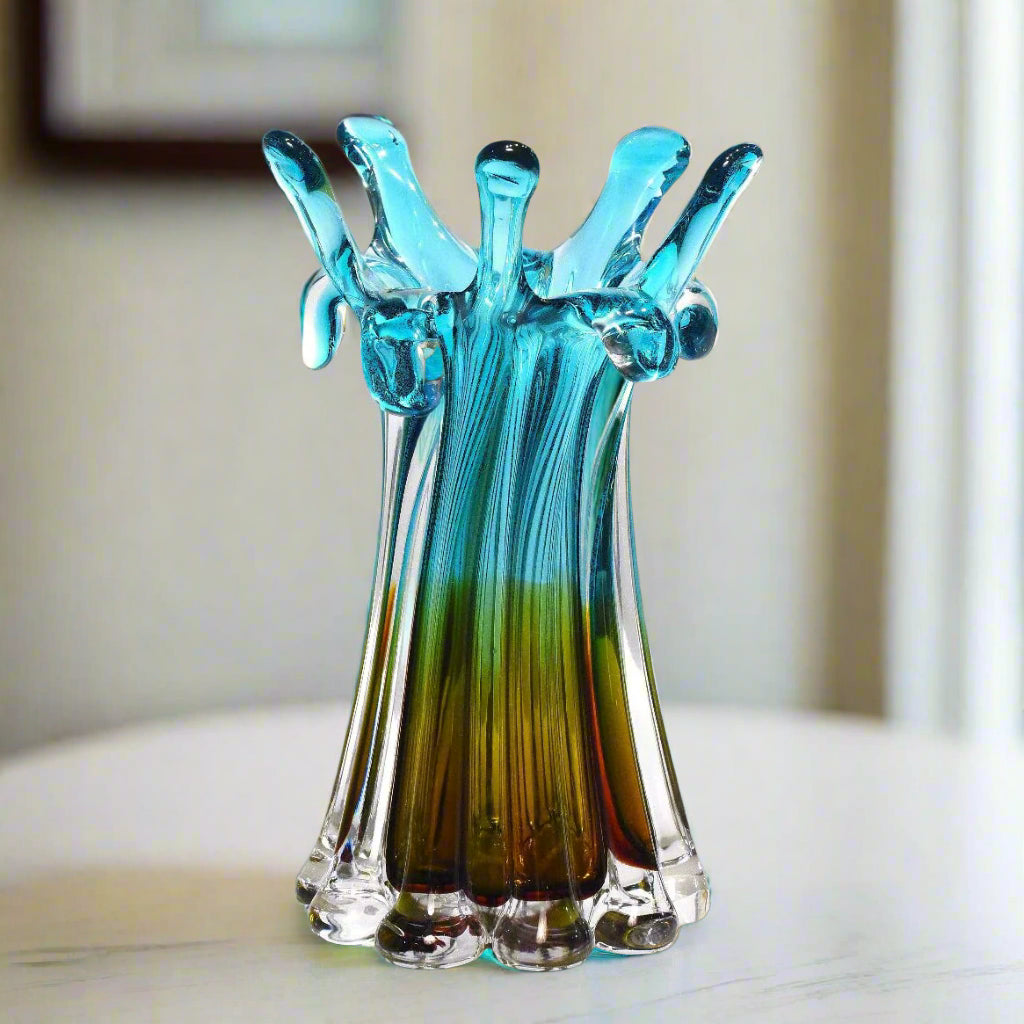 Glass sculpture resembling a hand with blue and green gradient