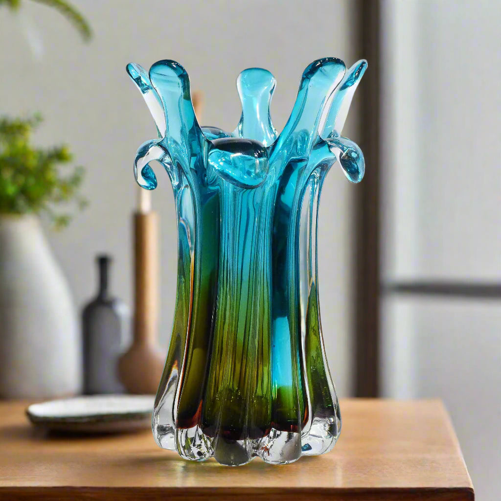 Blue and green glass vase with a unique design on a white background