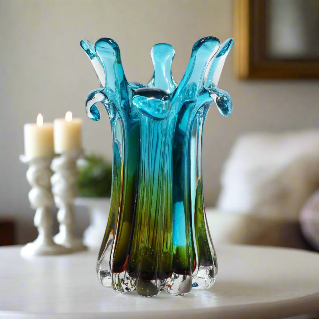 Blue and green glass vase with a unique design on a white background
