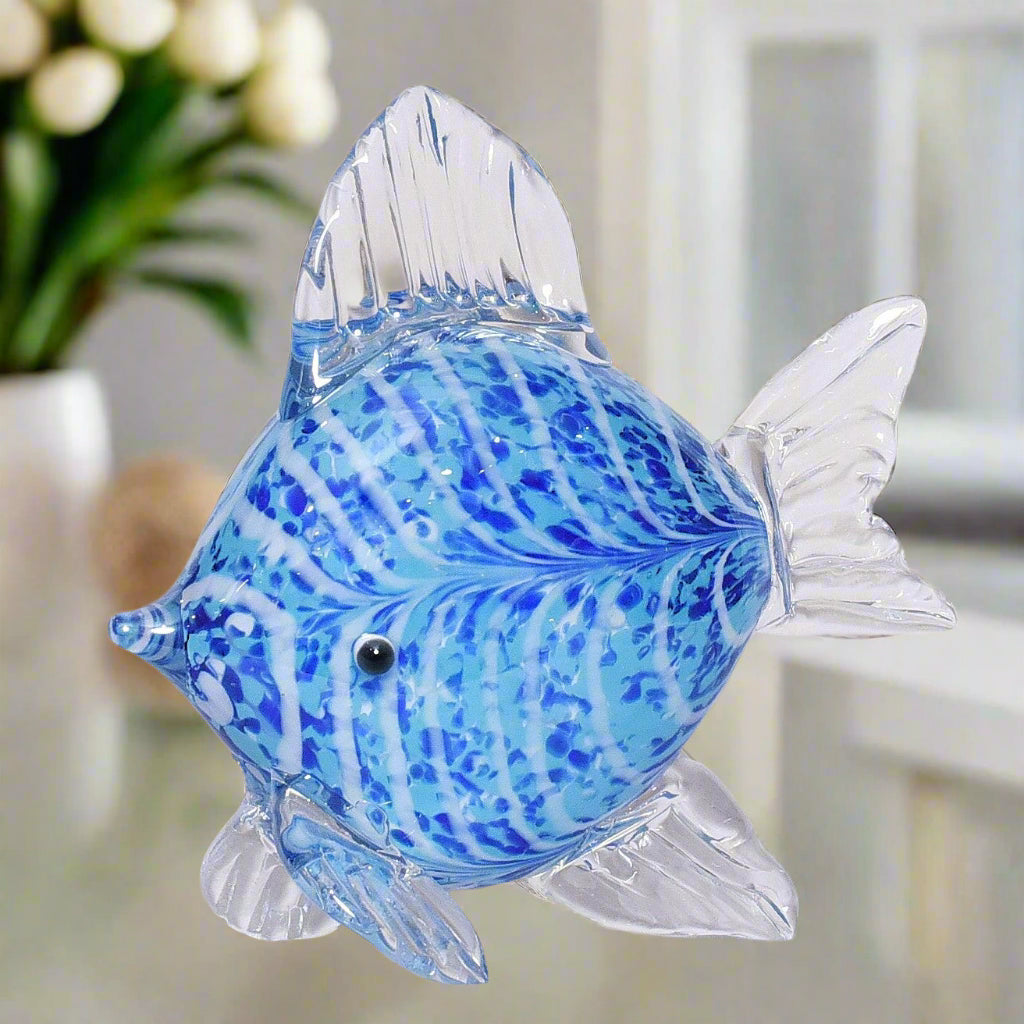 Glass fish figurine with blue and white pattern on a white background
