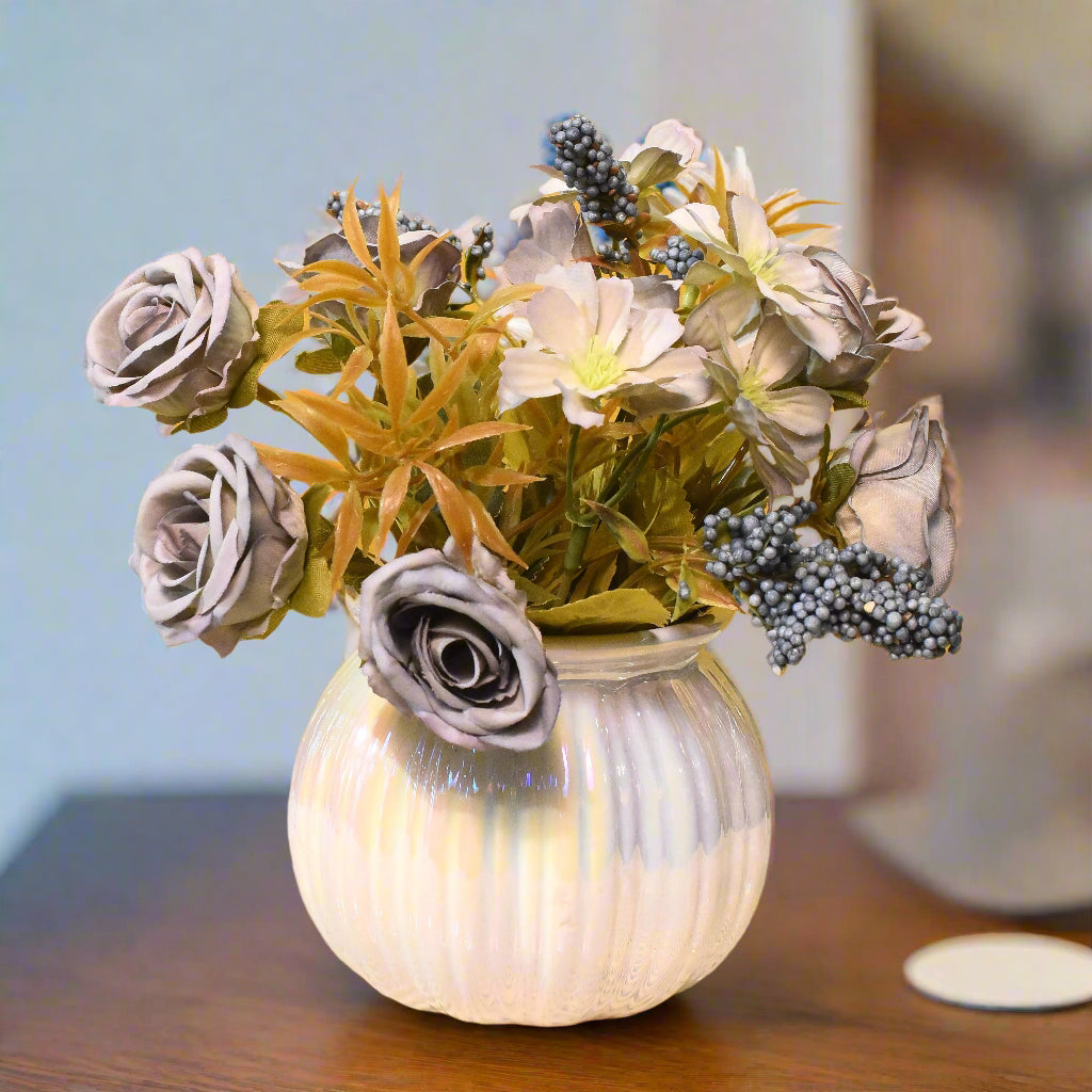 Decorative vase with artificial flowers on a textured surface against a yellow background