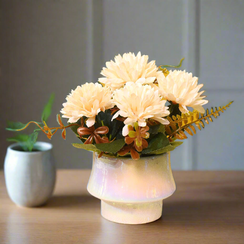 Floral arrangement in a white vase on a textured surface with a yellow background