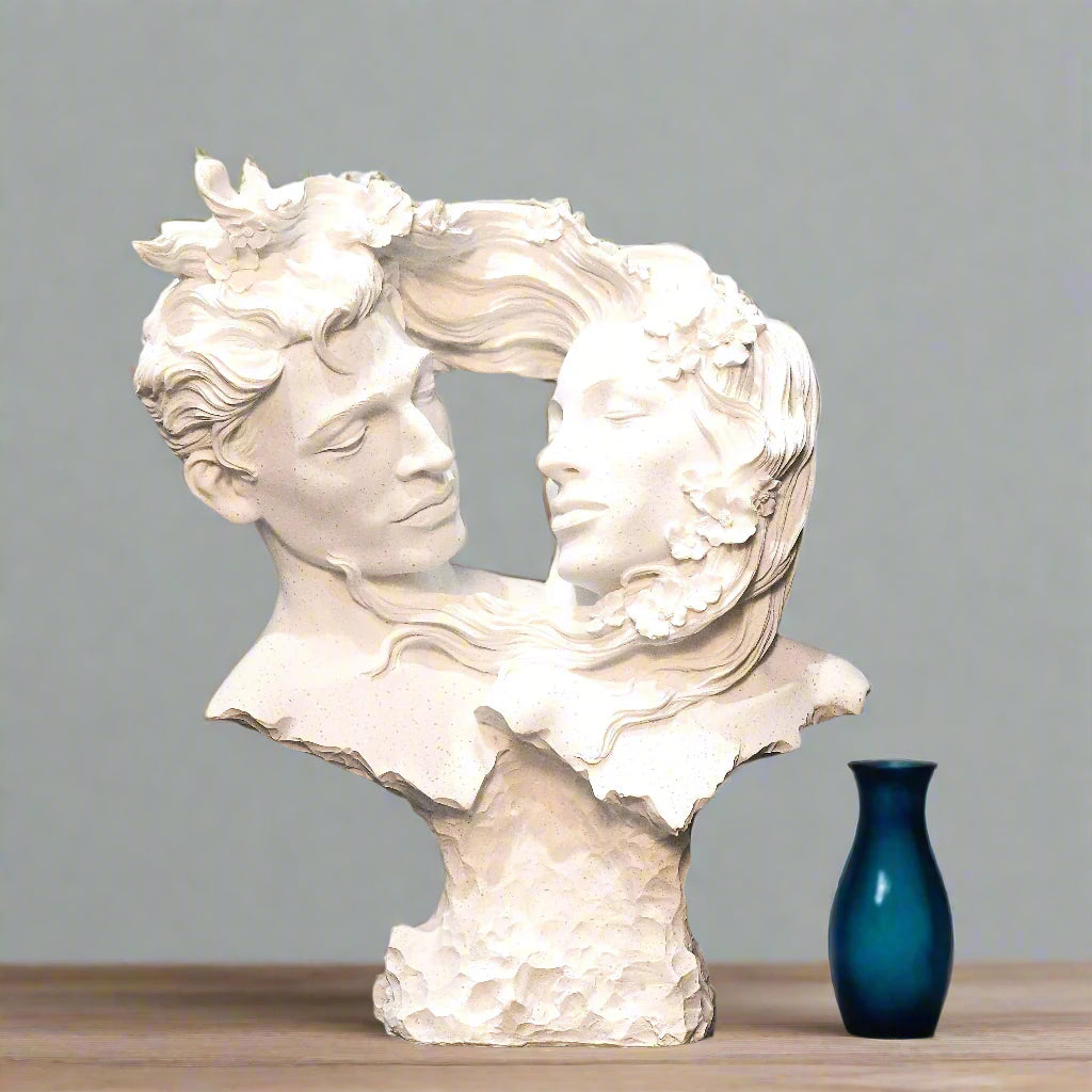White sculpture of two faces intertwined against a blue background