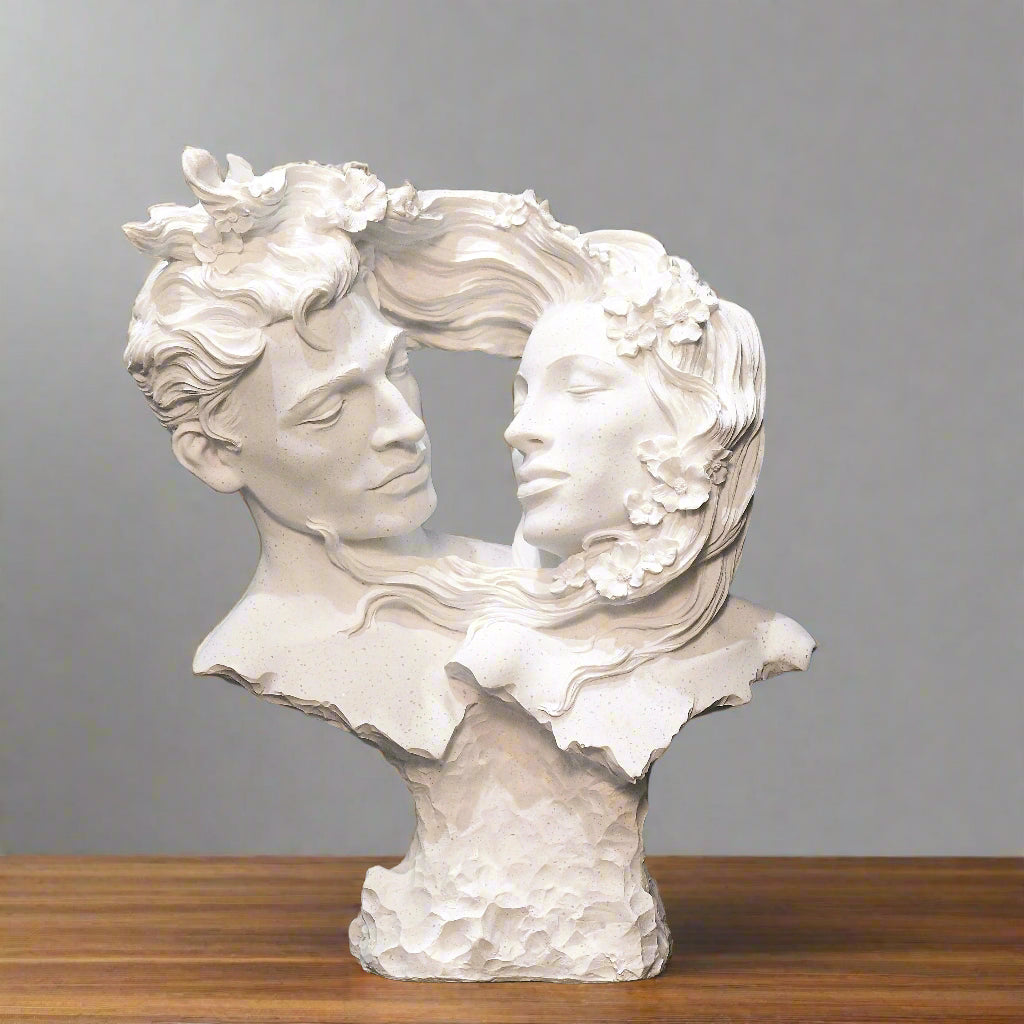White sculpture of two faces intertwined against a blue wall