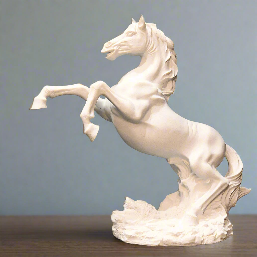 White horse sculpture on a wooden surface with decorative items in the background