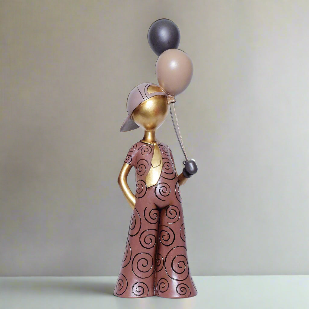 Decorative figurine of a person holding balloons against a white background