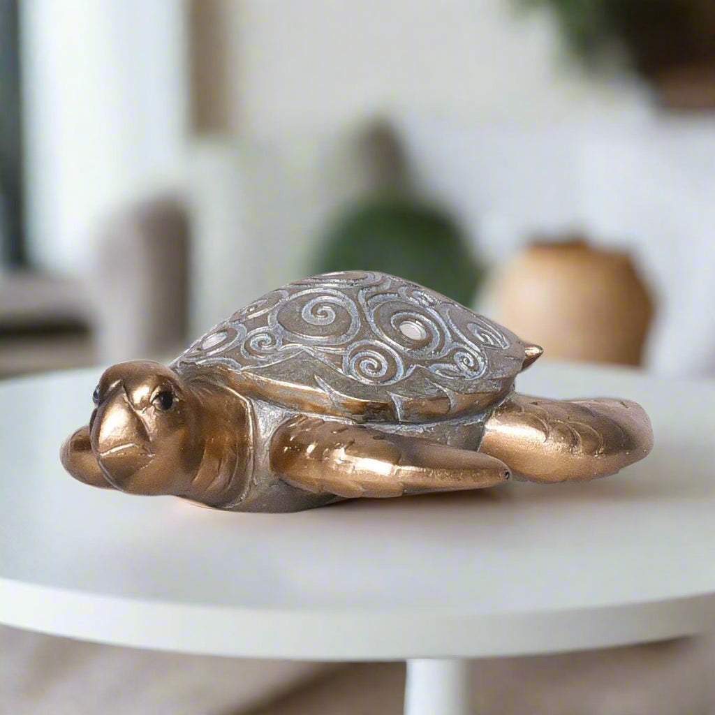 Decorative turtle sculpture on a white surface with a blurred indoor background