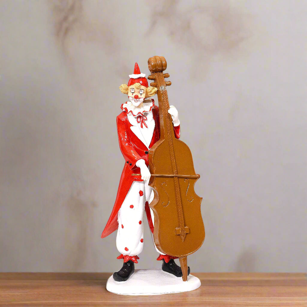 Figurine of a clown playing a cello on a wooden surface with a neutral background