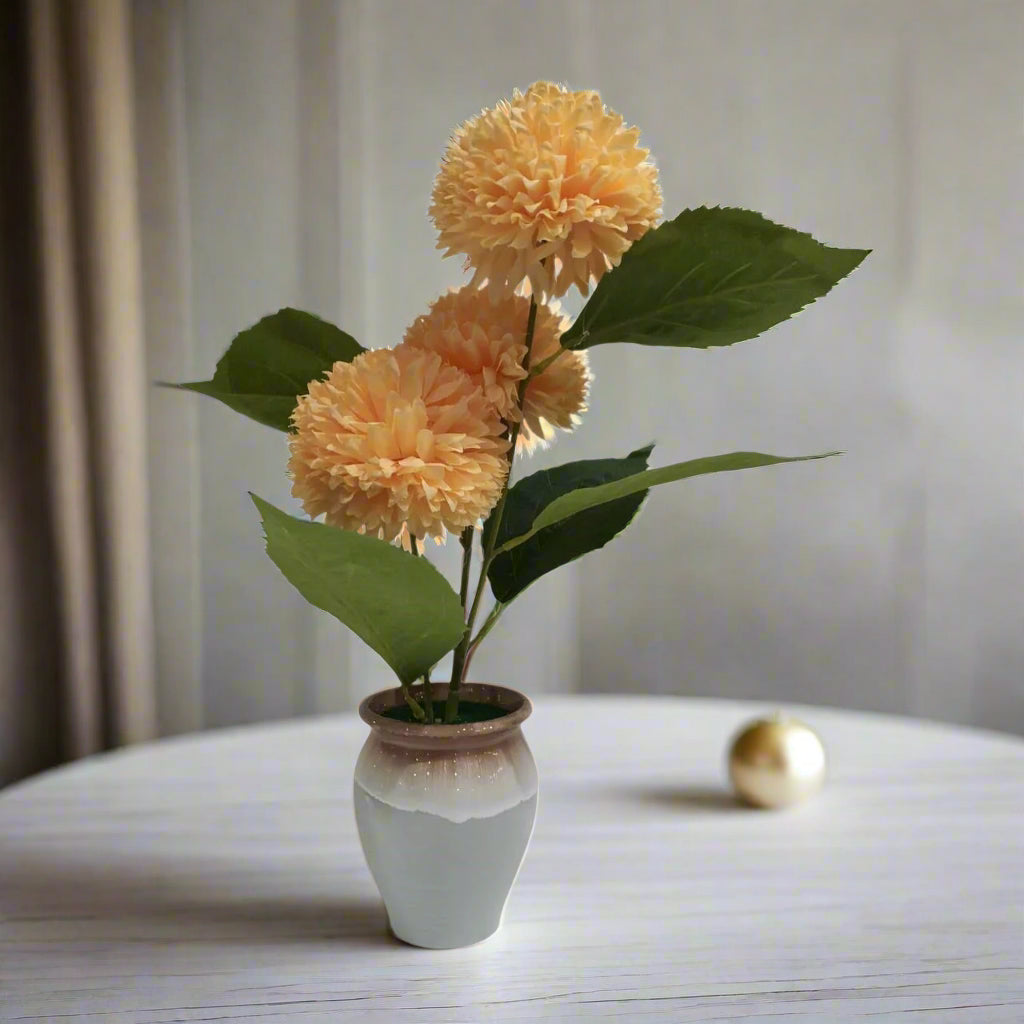 Decorative artificial flower arrangement in a pot on a table with a neutral background