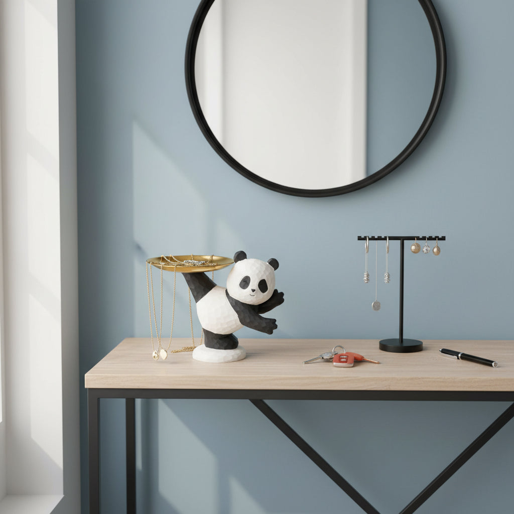 Panda figurine holding a gold plate on a wooden surface with a light blue background