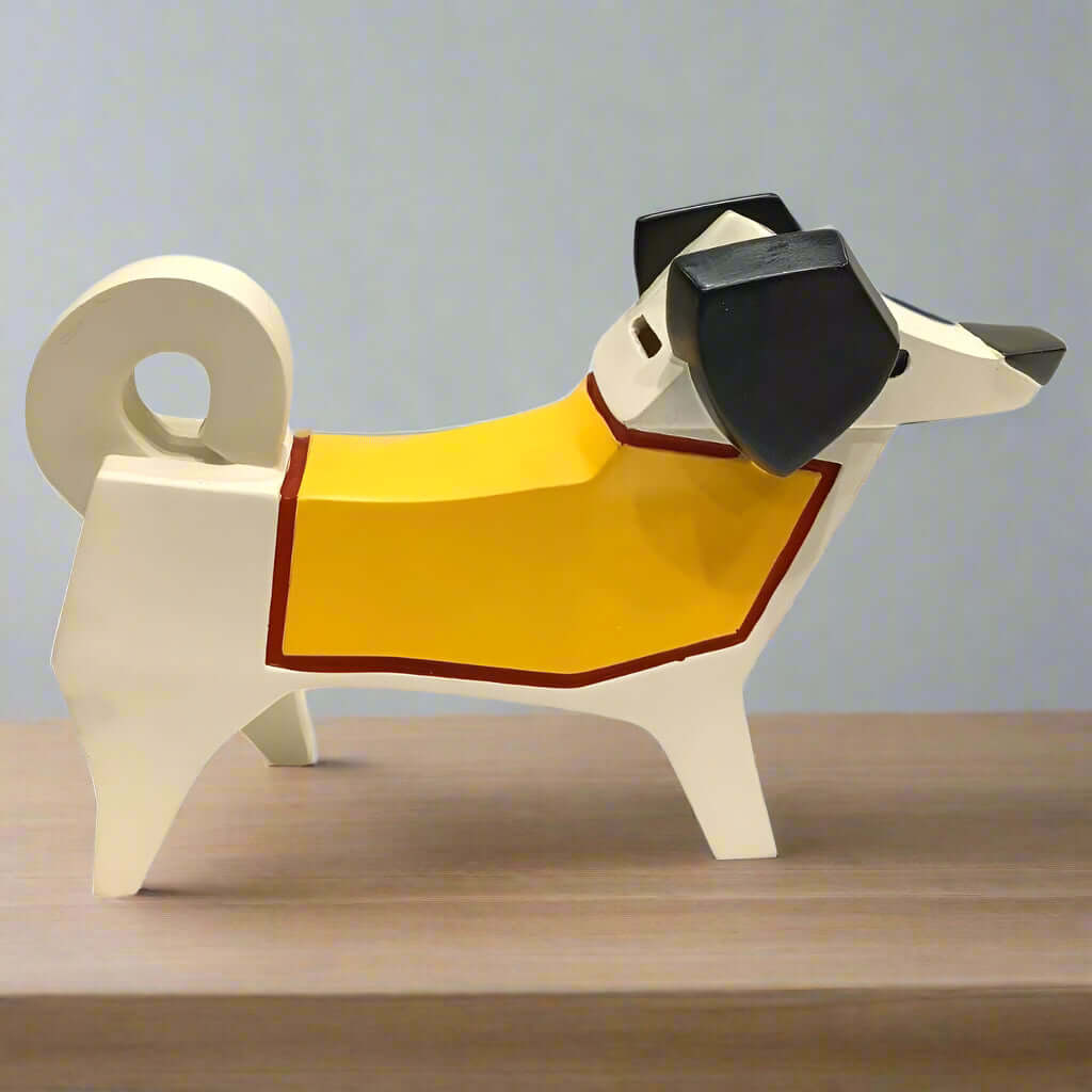 Dog-shaped object with a yellow blanket draped over it on a wooden surface.