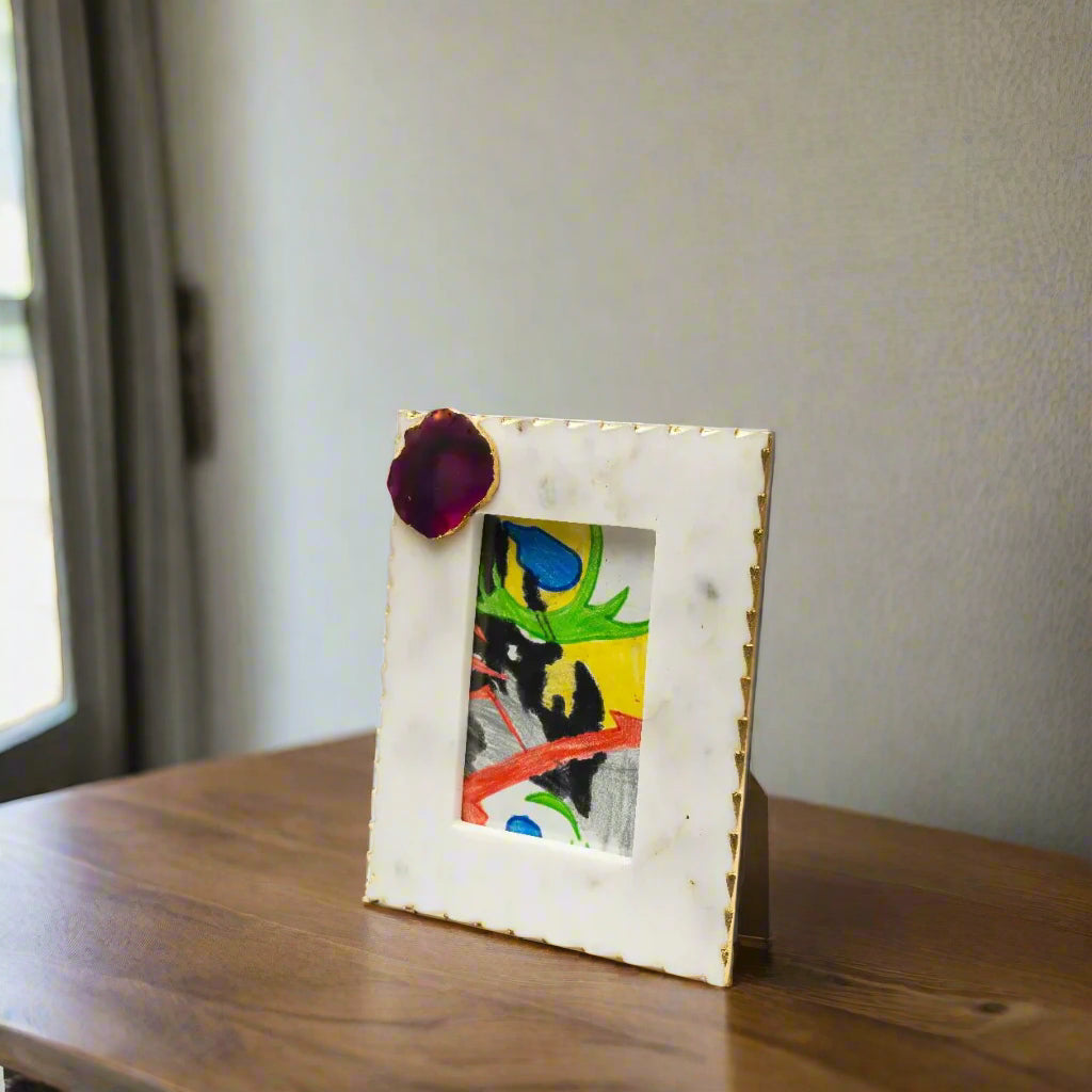 Marble picture frame with a colorful painting inside on a white background