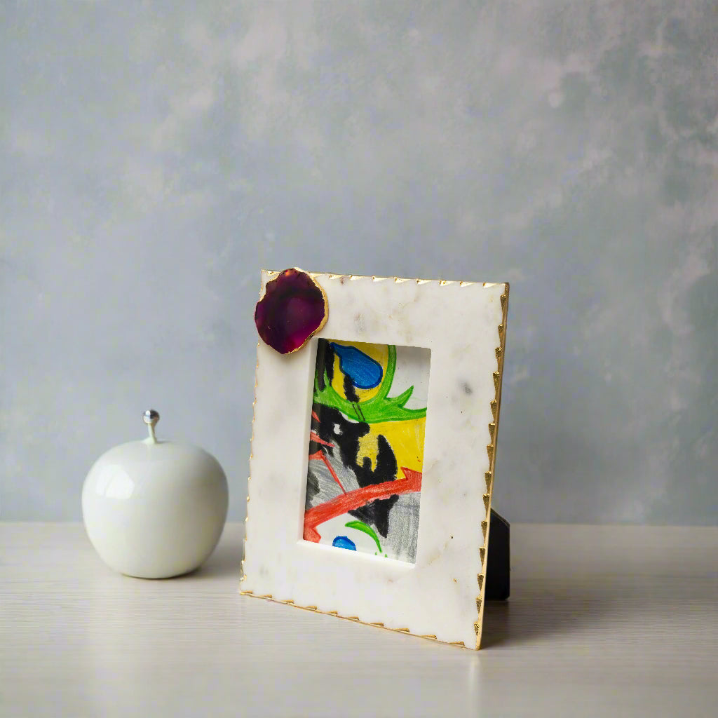 Marble picture frame with a colorful painting inside on a white background
