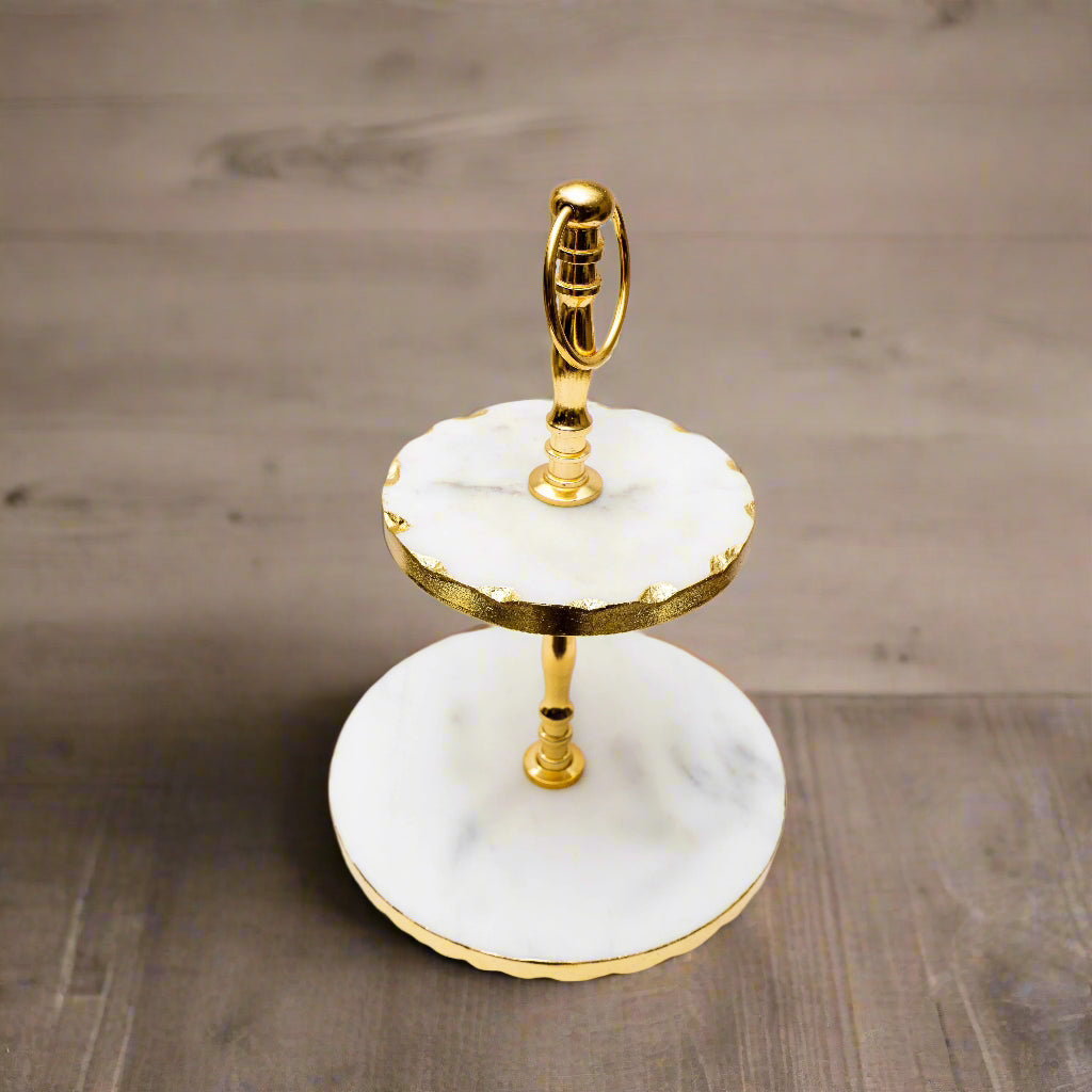 Two-tiered cake stand with gold accents on a white background