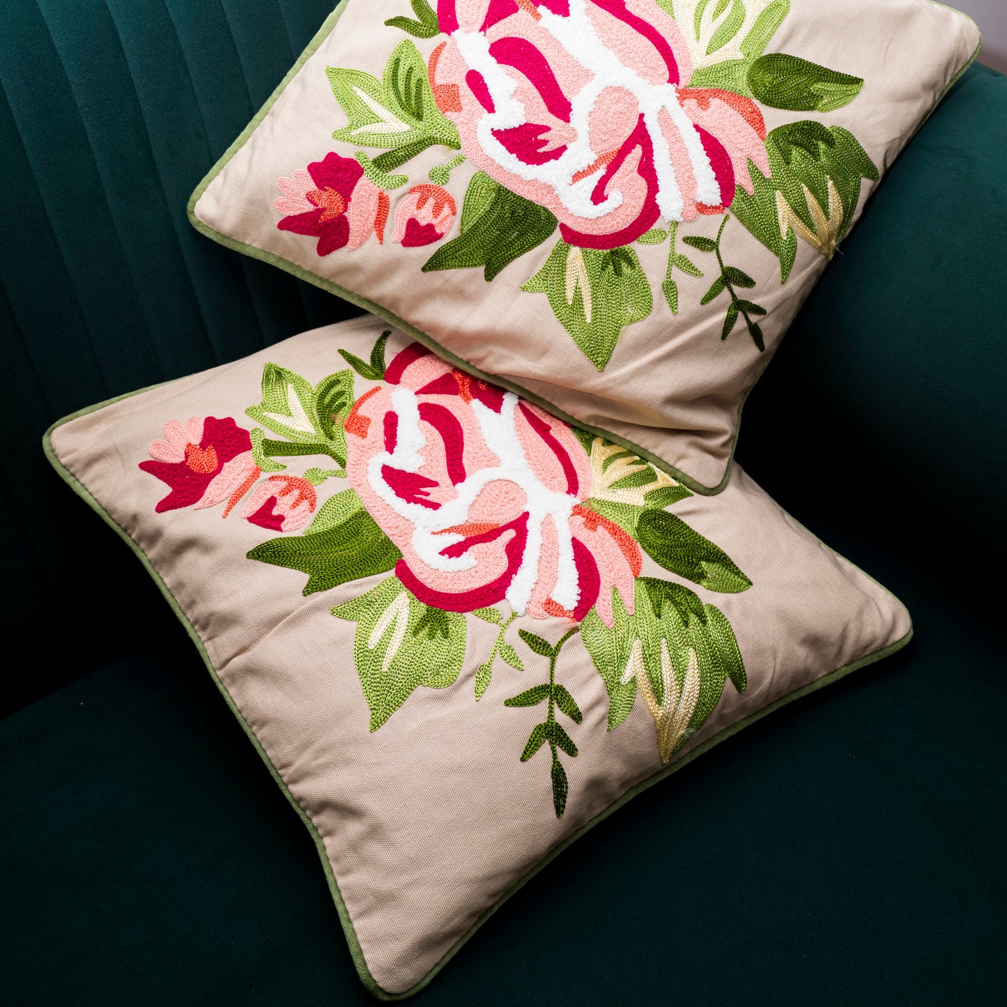 Two floral embroidered pillows on a dark surface