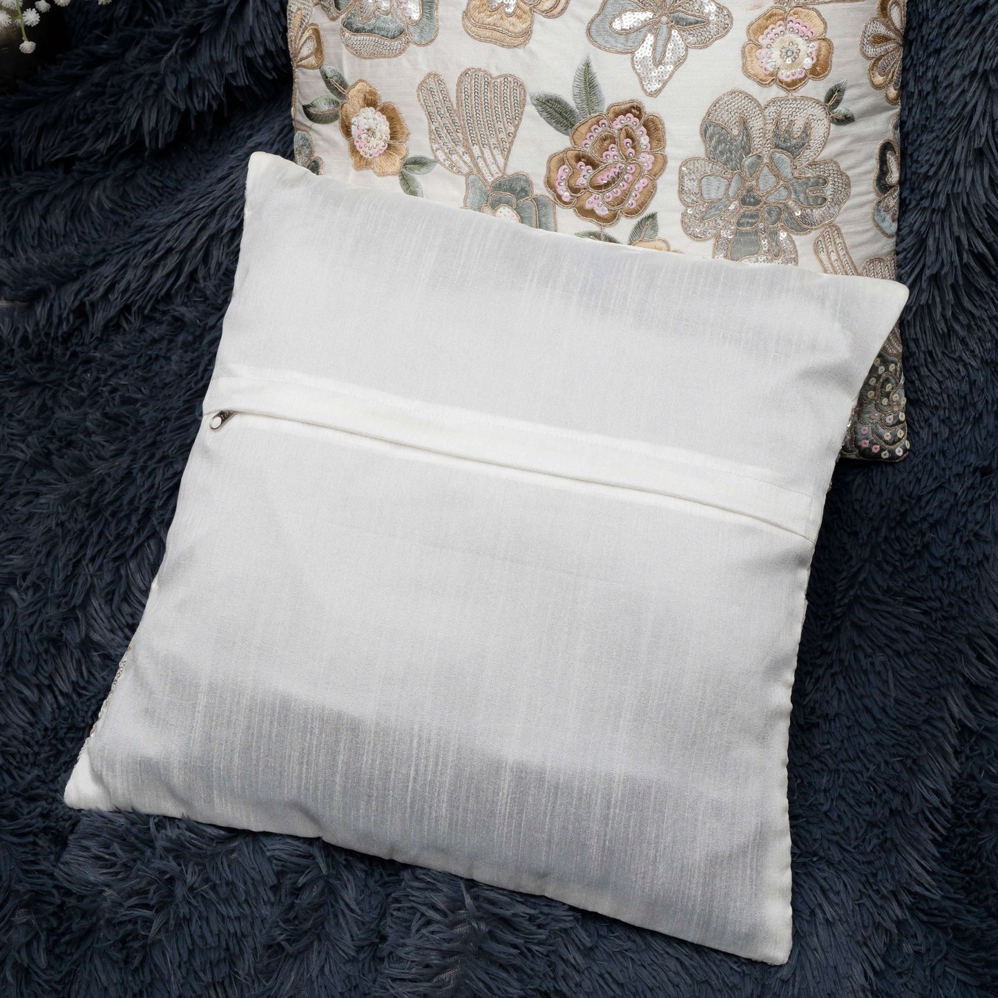White pillow with a zipper on a dark textured surface