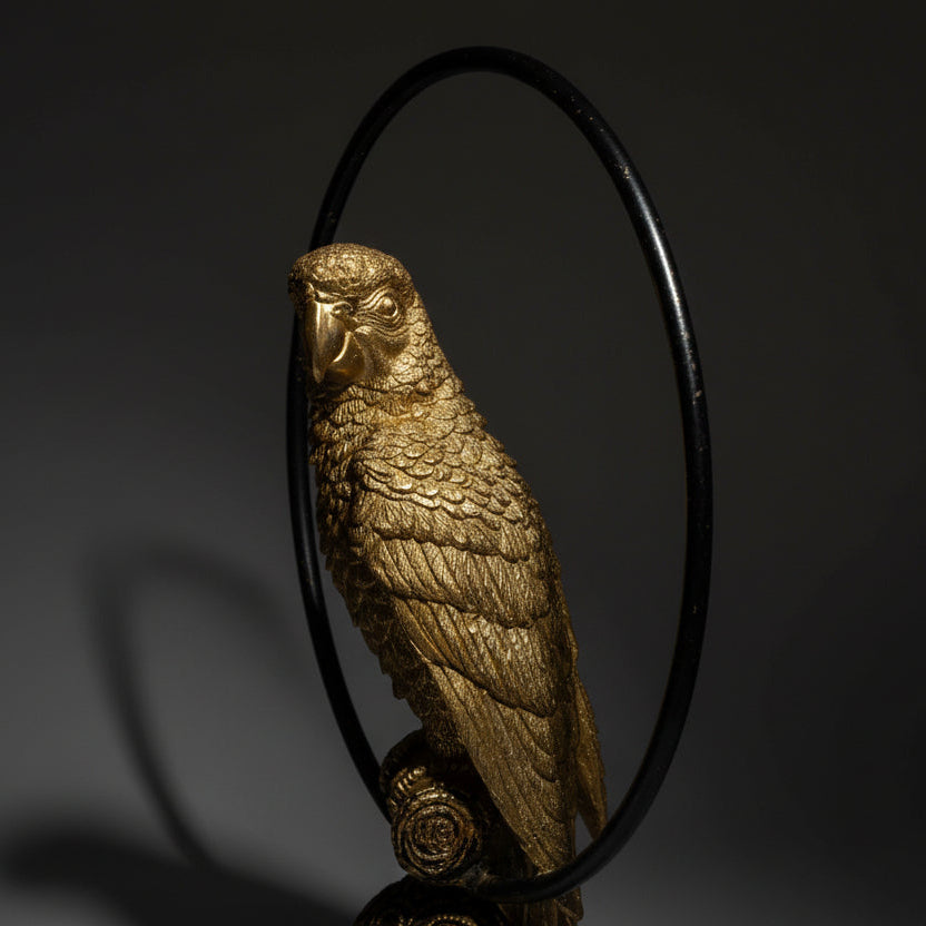 Bronze parrot sculpture on a white background
