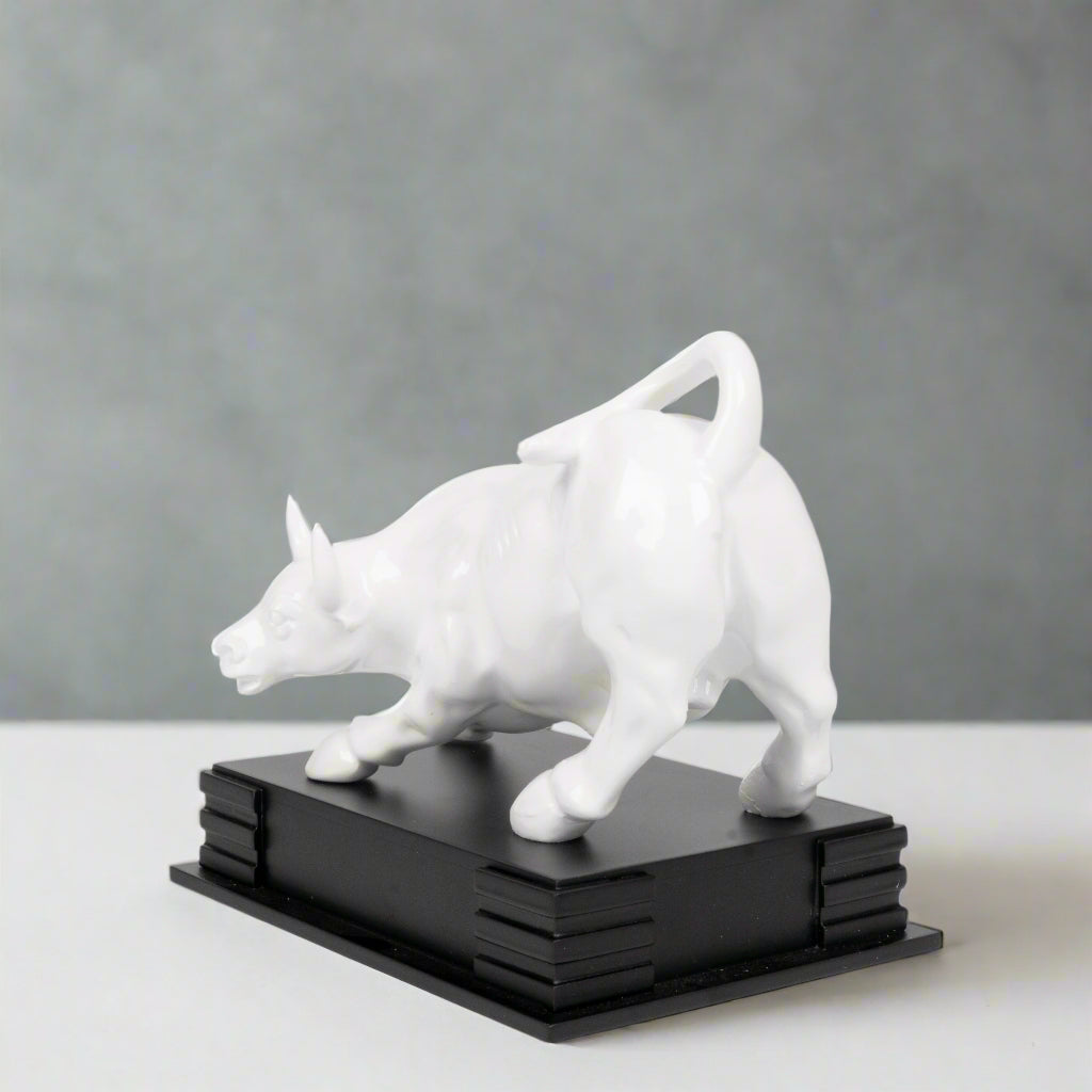 White dog sculpture on a black base against a light gray background
