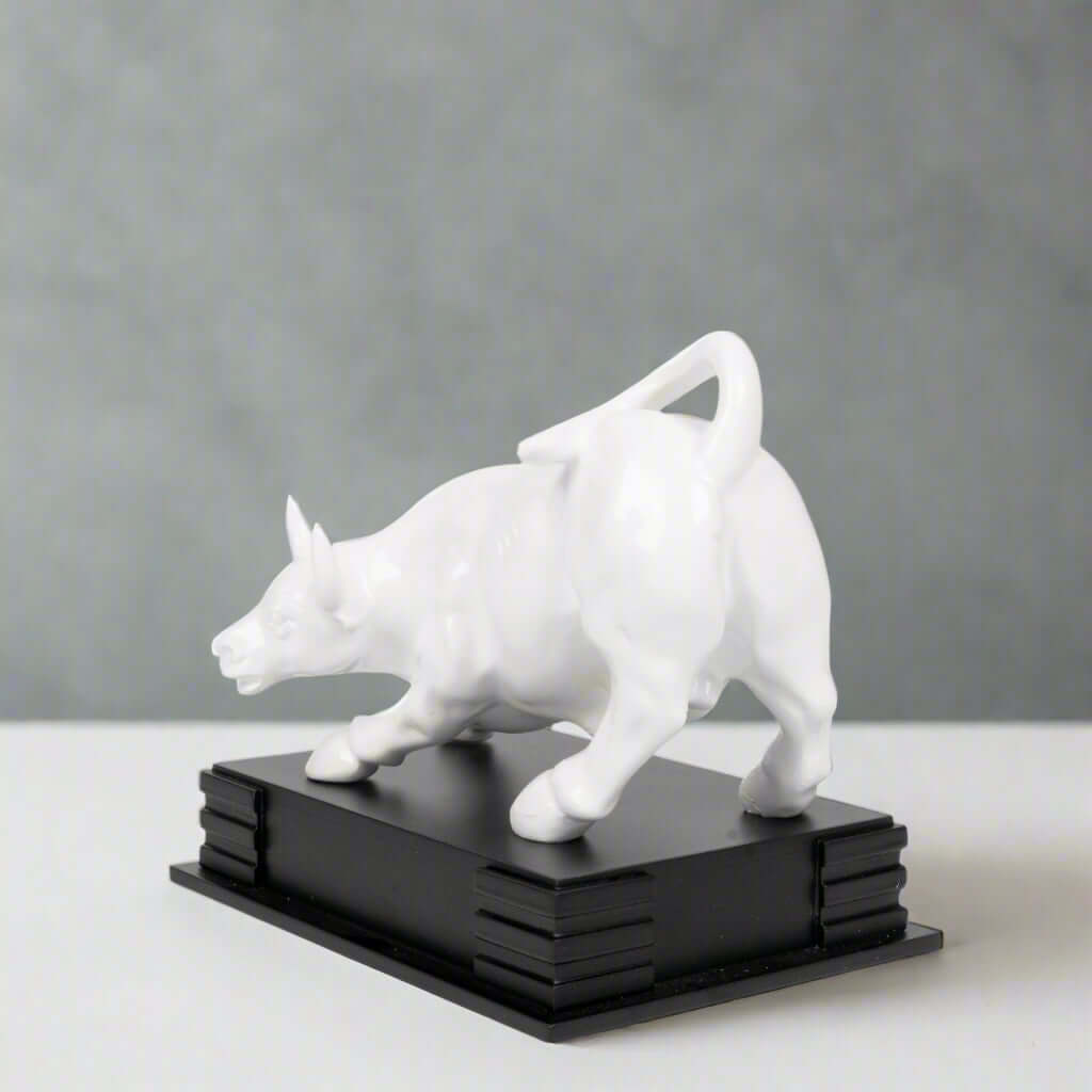 White dog sculpture on a black base against a light gray background