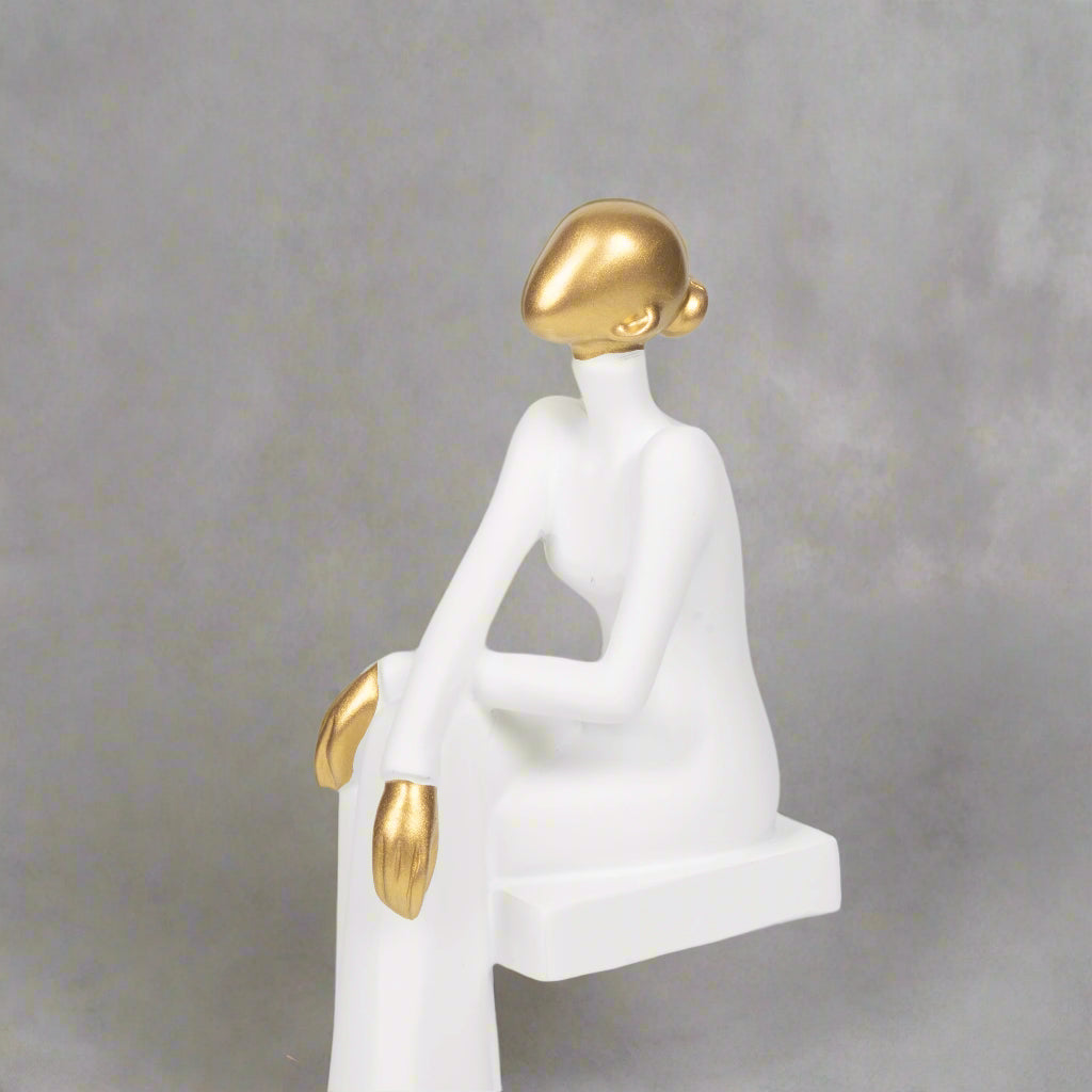 White and gold decorative figure on a light gray background