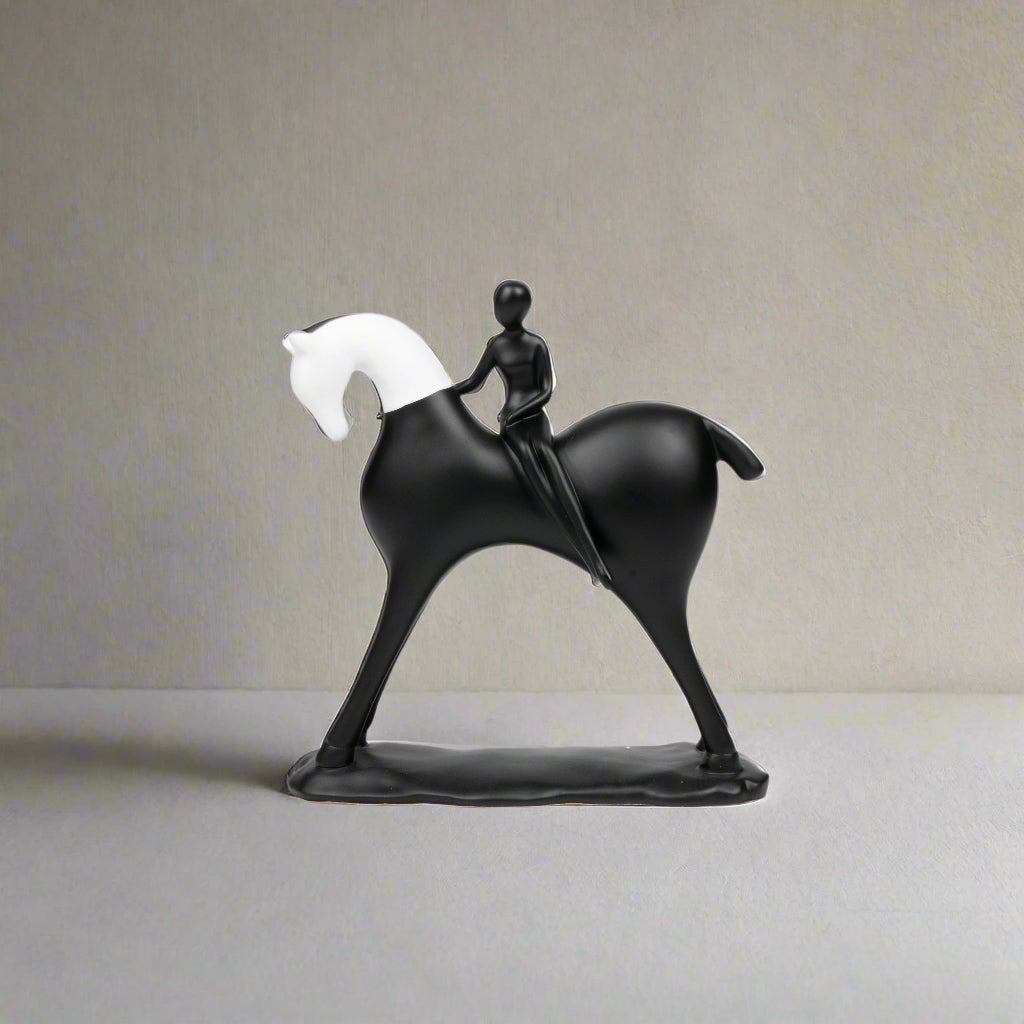 Black sculpture of a person riding a horse on a white background