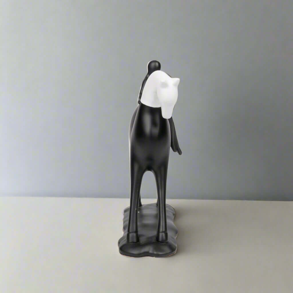 Black and white horse figurine on a plain background