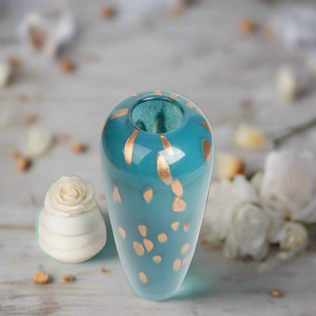 Teal ceramic vase with gold speckles on a white background