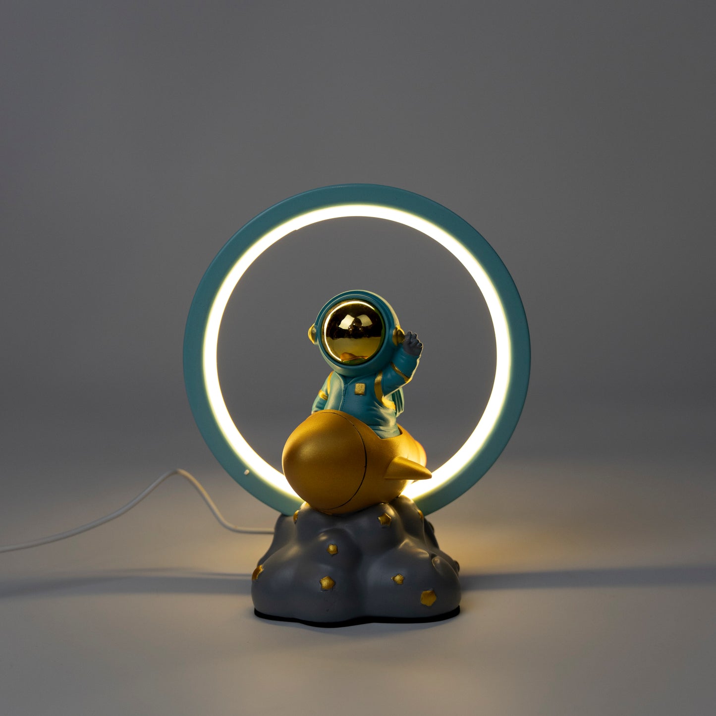 Decorative lamp with an astronaut figure on a cloud and a neon ring light.