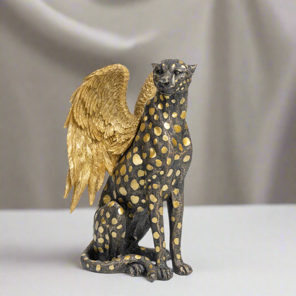 Statue of a winged creature with gold accents on a white background