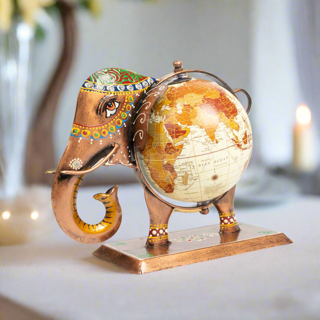 Decorative elephant figurine holding a world globe on a white background