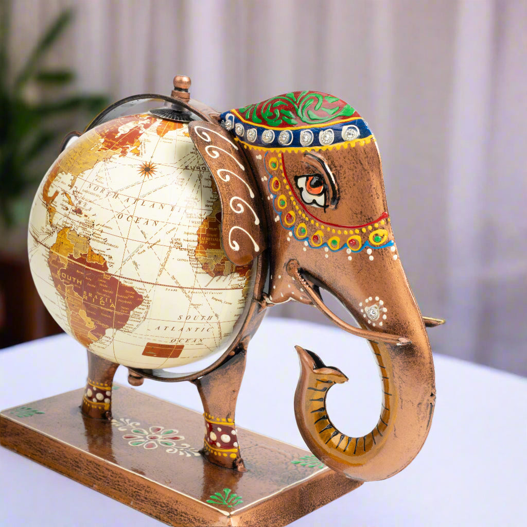 Decorative elephant figurine with a world globe on its back against a white background