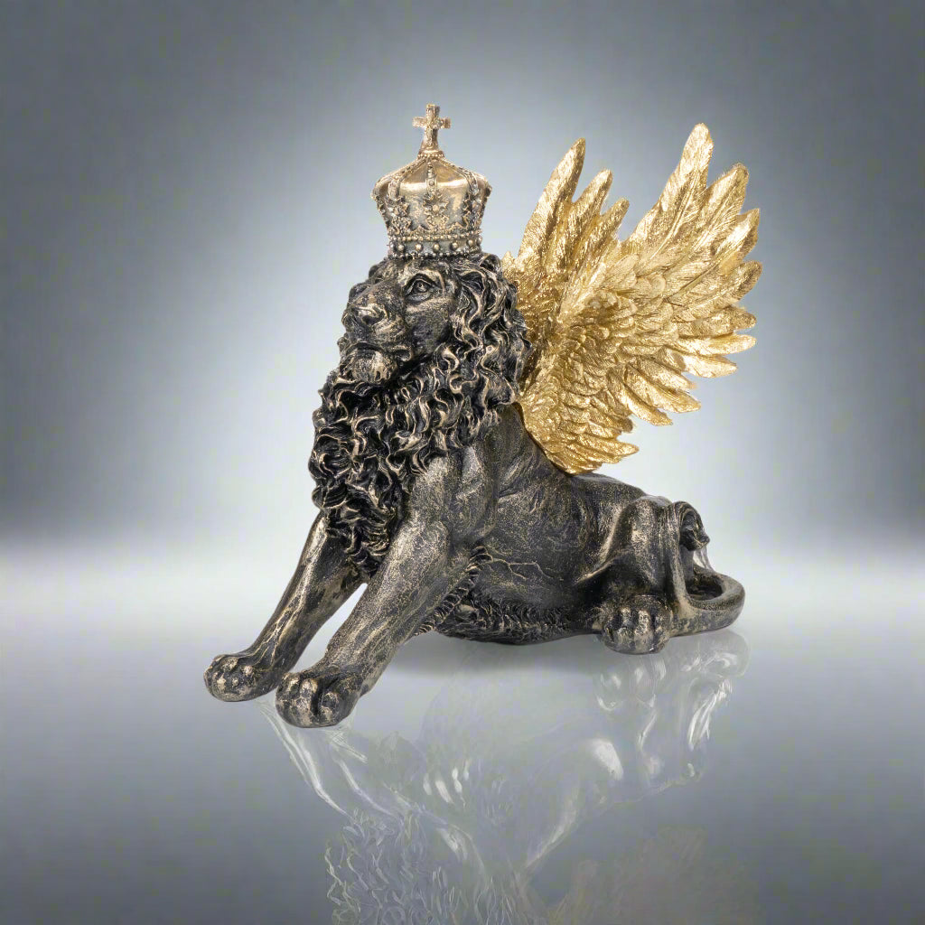 Statue of a lion with gold wings and a crown on a reflective surface