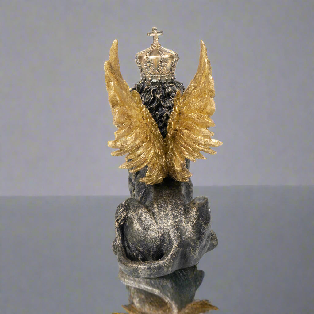 Statue of an angel with gold wings and a crown on a white background