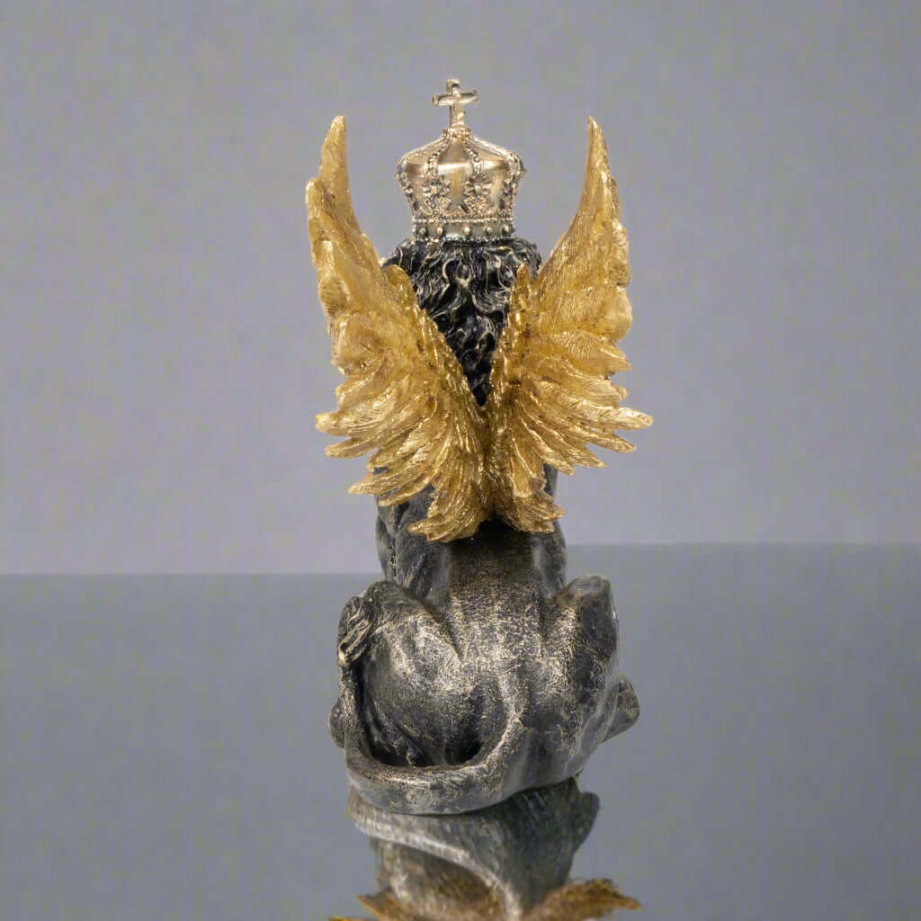 Statue of an angel with gold wings and a crown on a white background