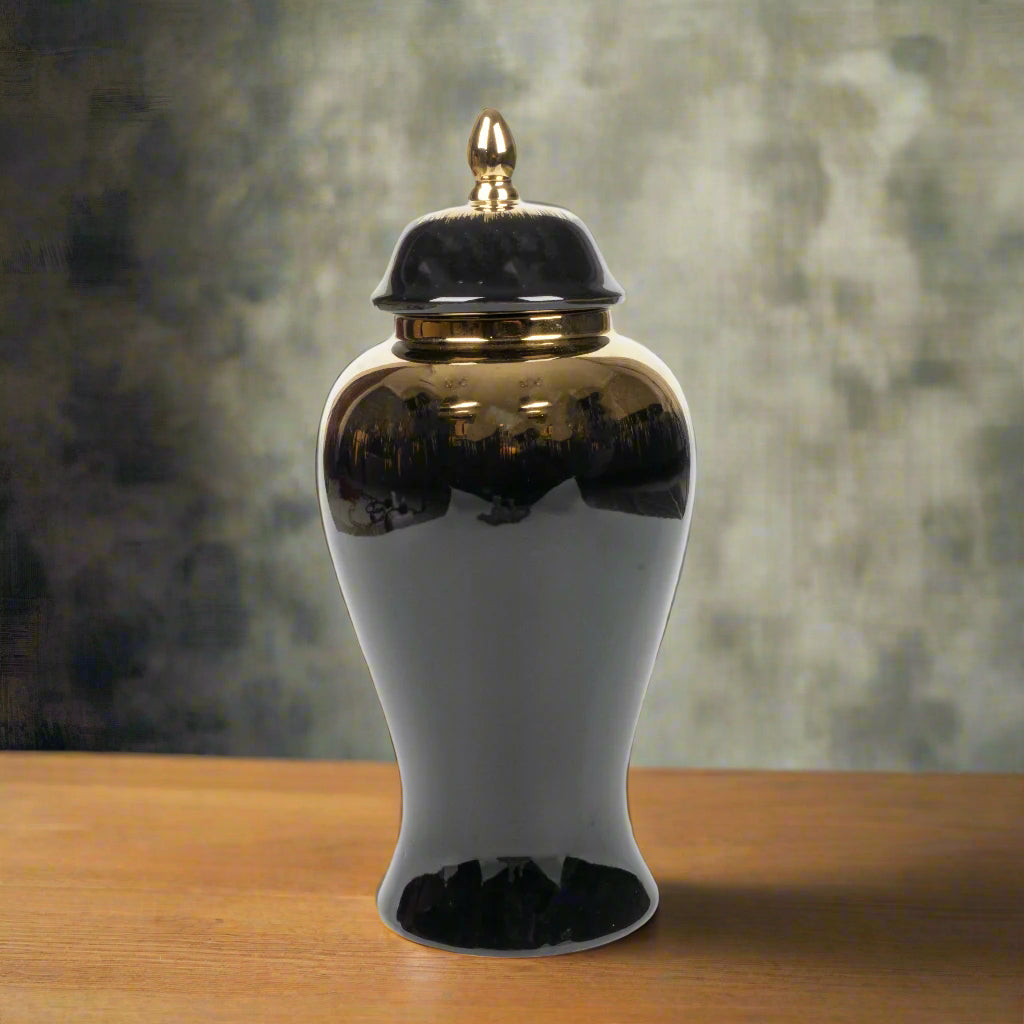 Black ceramic jar with gold lid on a white background