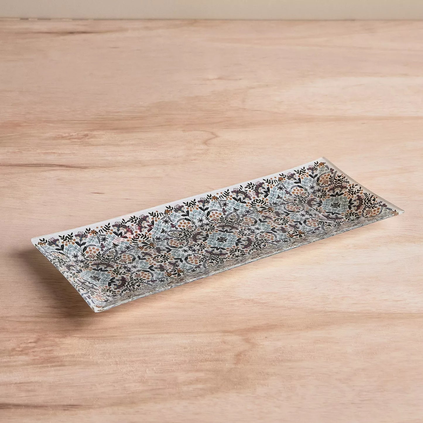 Decorative rectangular plate with floral pattern on a wooden surface