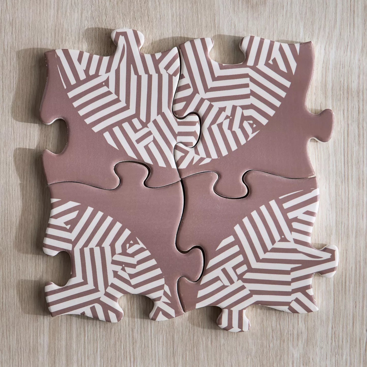Four puzzle pieces with geometric pattern on a wooden surface