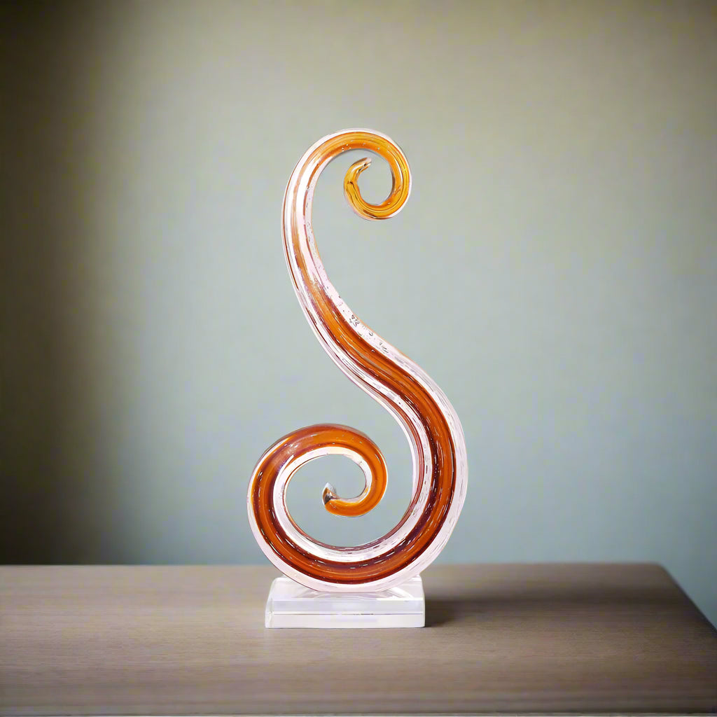 Decorative swirl sculpture on a white platform against a beige wall