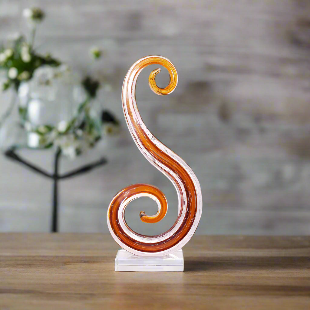 Decorative swirl sculpture on a white platform against a beige wall